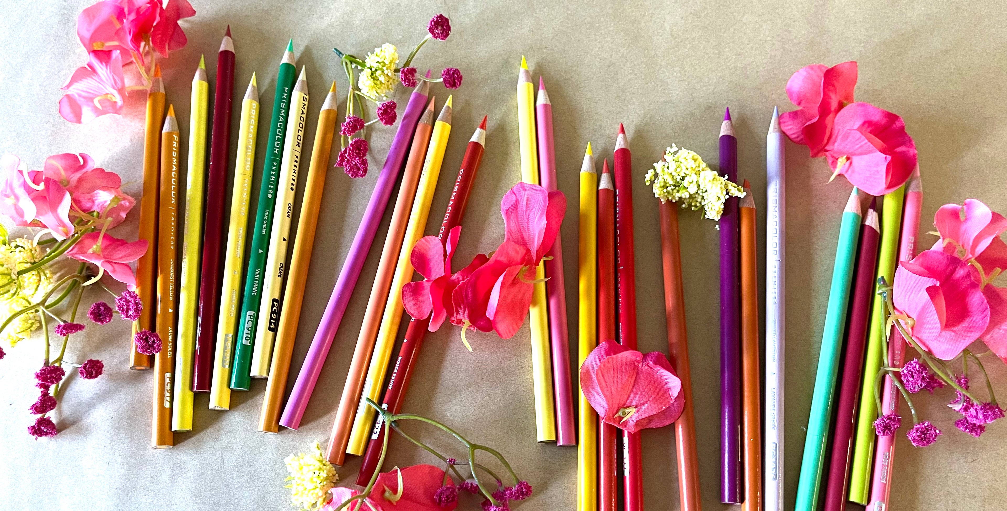 Colorful pencils with flowers on a textured surface