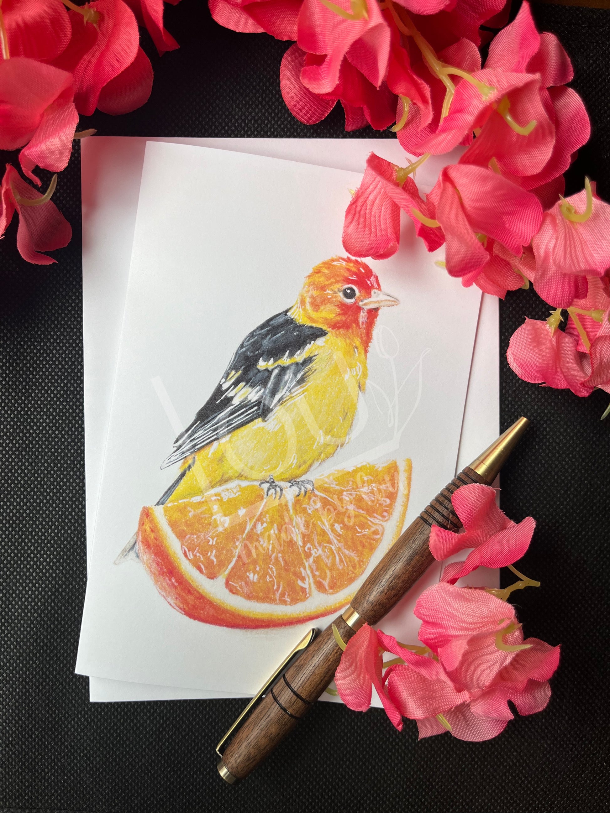 Card with bird illustration, pen, and pink flowers on a black background